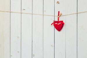 decoratief rood harten hangende Aan wijnoogst houten achtergrond met ruimte. Valentijn achtergrond. foto