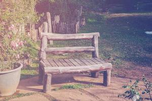 hout stoel in tuin en zonlicht met wijnoogst toon. foto