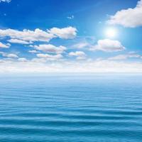 zee en blauw lucht met zon foto