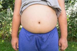 jongen dik en ongezond met natuurlijk achtergrond. foto