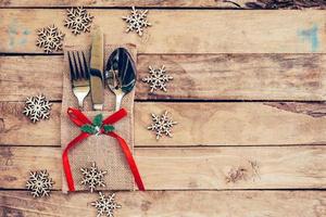 Kerstmis tafel plaats instelling en zilverwerk, sneeuwvlokken Aan tafel houten achtergrond met ruimte voor kerstmis. foto