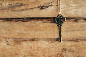oud sleutel hangende Aan bruin hout met ruimte. foto