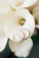 luxe rijk ringen bruiloft ringen detailopname Aan een bloemblad van wit calla foto