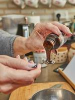 chef bereidt zich voor taart siroop in een metaal kom in de keuken foto