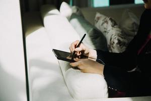 volwassen zakenman gebruik makend van een digitaal tablet naar bespreken informatie met een jonger collega in een modern bedrijf lounge foto