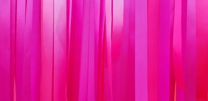 roze of rood lint achtergrond of muur. pastel en kleurrijk papier of kleding stof decoratie in partij, festival, bruiloft en viering concept. foto