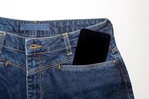 een modern telefoon in een jeans zak- weergeven de app Aan een zwart scherm. foto