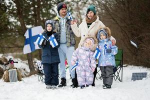 Fins familie met Finland vlaggen Aan een mooi hoor winter dag. nordic Scandinavisch mensen. foto