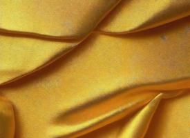 glimmend gouden kleding stof textiel voor elegant behang ontwerp foto