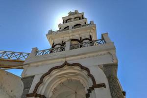 orthodox kerk met haar meerlagig klok toren facade in emporio, santorini, Griekenland. foto