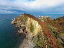 stilte strand, zilver-zanderig inham gesteund door een natuurlijk rots amfitheater in Asturië, Spanje. foto