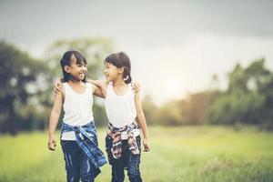 twee kleine meisjes die plezier hebben in het park foto