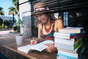 jonge vrouw die een boek leest in een café foto