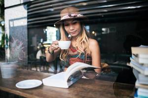 vrouw cappuccino drinken en een boek lezen foto