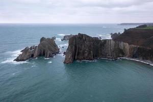 stilte strand, zilver-zanderig inham gesteund door een natuurlijk rots amfitheater in Asturië, Spanje. foto