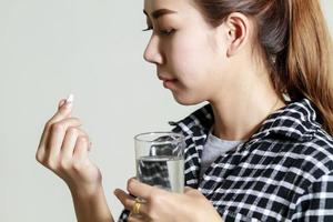 Aziatische vrouw die medicijnen gebruikt foto