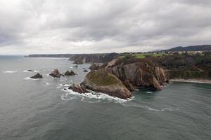 stilte strand, zilver-zanderig inham gesteund door een natuurlijk rots amfitheater in Asturië, Spanje. foto