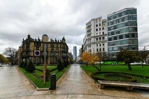 Bilbao, Spanje - nov 26, 2021, plein de federico moyu of elliptisch plein in de stad centrum, met Engels en Franse stijl bloem bedden, modern staal lantarenpaal en meubilair. foto