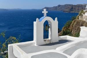 charmant visie oia dorp Aan Santorini eiland, Griekenland. traditioneel beroemd blauw koepel kerk over- de caldera in Egeïsch zee. traditioneel blauw en wit cycladen architectuur. foto