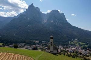 st. Valentin kastelruth dorp kerk in de zomer in de dolomiet Alpen. verbazingwekkend landschap met klein kapel Aan zonnig weide en petz top Bij kastelruth gemeente. dolomieten, zuiden Tirol, Italië foto