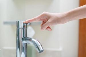 opslaan water. vrijwilliger houdt draaien uit de rennen water in de badkamer naar beschermen omgeving. vergroening planeet, verminderen globaal opwarming, opslaan wereld, leven, toekomst, risico energie, crisis , water dag. foto