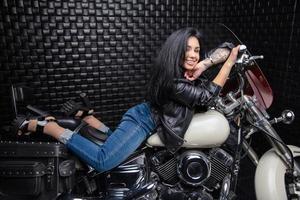 mooi vrouw aan het liegen Aan een motorfiets foto