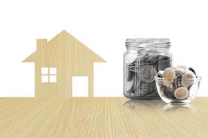munten in een glas pot van buying een nieuw huis - besparing geld voor toekomst idee, huis spaargeld munten. geïsoleerd Aan wit achtergrond foto