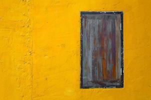 bruin hout venster Aan helder oranje beton muur foto