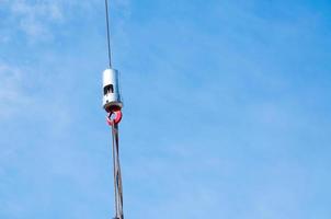 de haak van verheffen kraan liften een beton bord tegen de blauw lucht, dichtbij omhoog foto