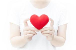 vrouw Holding en beschermen een rood hart vorm Aan wit achtergrond close-up, symbool van liefde of dating valentijnsdag dag foto
