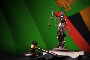 Zambia vlag met standbeeld van dame gerechtigheid, grondwet en rechter hamer Aan zwart draperie. concept van oordeel en schuld foto