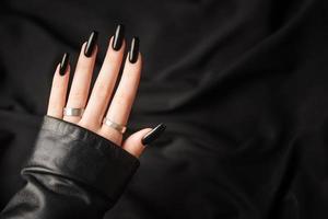 handen van een jong meisje met zwart manicure Aan nagels foto