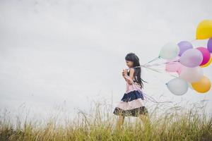 meisje speelt met ballonnen op weiden veld foto