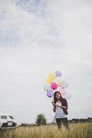 mooie jonge hipster vrouw met kleurrijke ballonnen buitenshuis foto