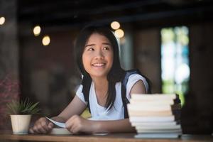 jonge vrouw leesboek binnen zitten in een stedelijk café