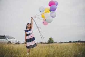 meisje speelt met ballonnen op weiden veld foto