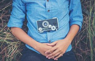 jonge hipster vrouw met een vintage camera liggen in een veld foto