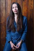 charmant brunette gekleed in denim overall foto