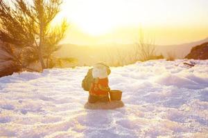 de kerstman in de sneeuw en zonsondergang in de achtergrond foto