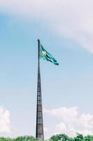 braziliaans vlag vliegen, fladderend in de wind en met de blauw lucht in de achtergrond. foto