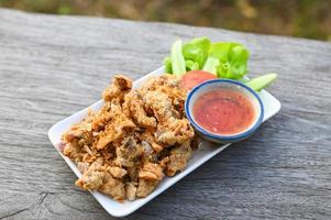 gebakken varkensvlees darm met knoflook met saus Aan bord - varkensvlees slachtafval Thais voedsel of snacks foto