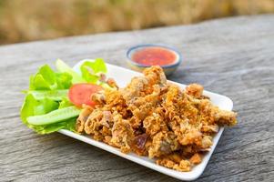 gebakken varkensvlees darm met knoflook met saus Aan bord - gebakken varkensvlees slachtafval Thais voedsel of snacks foto