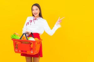 mooie jonge Aziatische vrouw met winkelmandje foto
