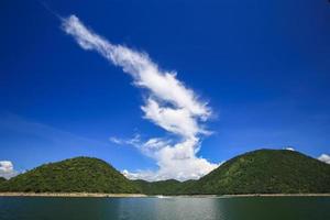 wolken boven groene heuvels en water foto