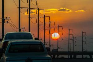 auto's en elektrische posten bij zonsondergang