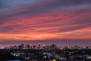 roze wolken boven een stad bij zonsondergang foto