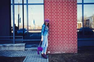 modieus vrouw staand Bij de steen muur foto