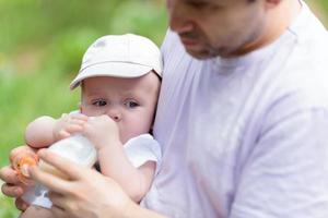 vader die zijn baby uit de fles voedt foto