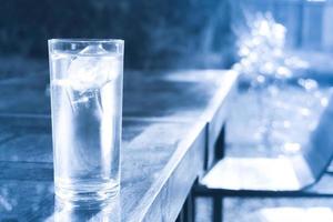 glas van schoon water met ijs Aan tafel, drinken water foto