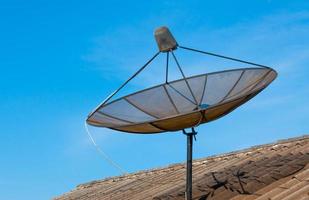 satelliet schotel Aan de oud dak met de blauw lucht achtergrond in de ochtend- foto